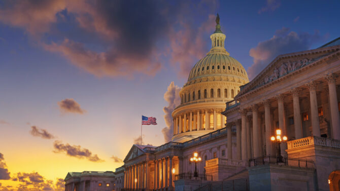 The United States Capitol stands against a sunset.